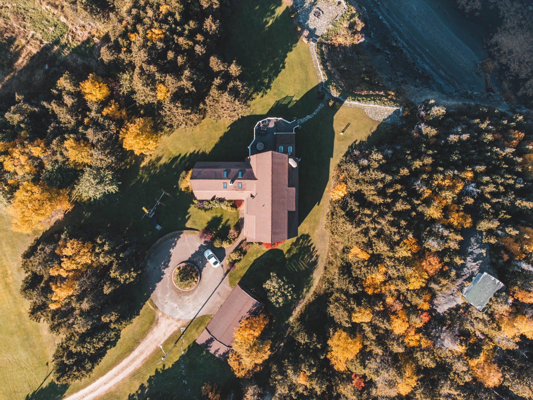 Aerial of secluded home surrounded by autumn trees