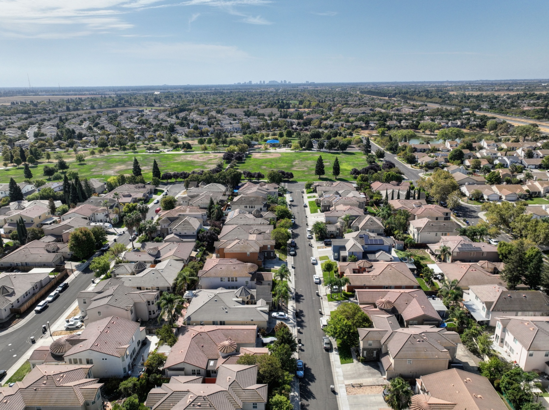 Aerial of residential neighborhood with distant city skyline