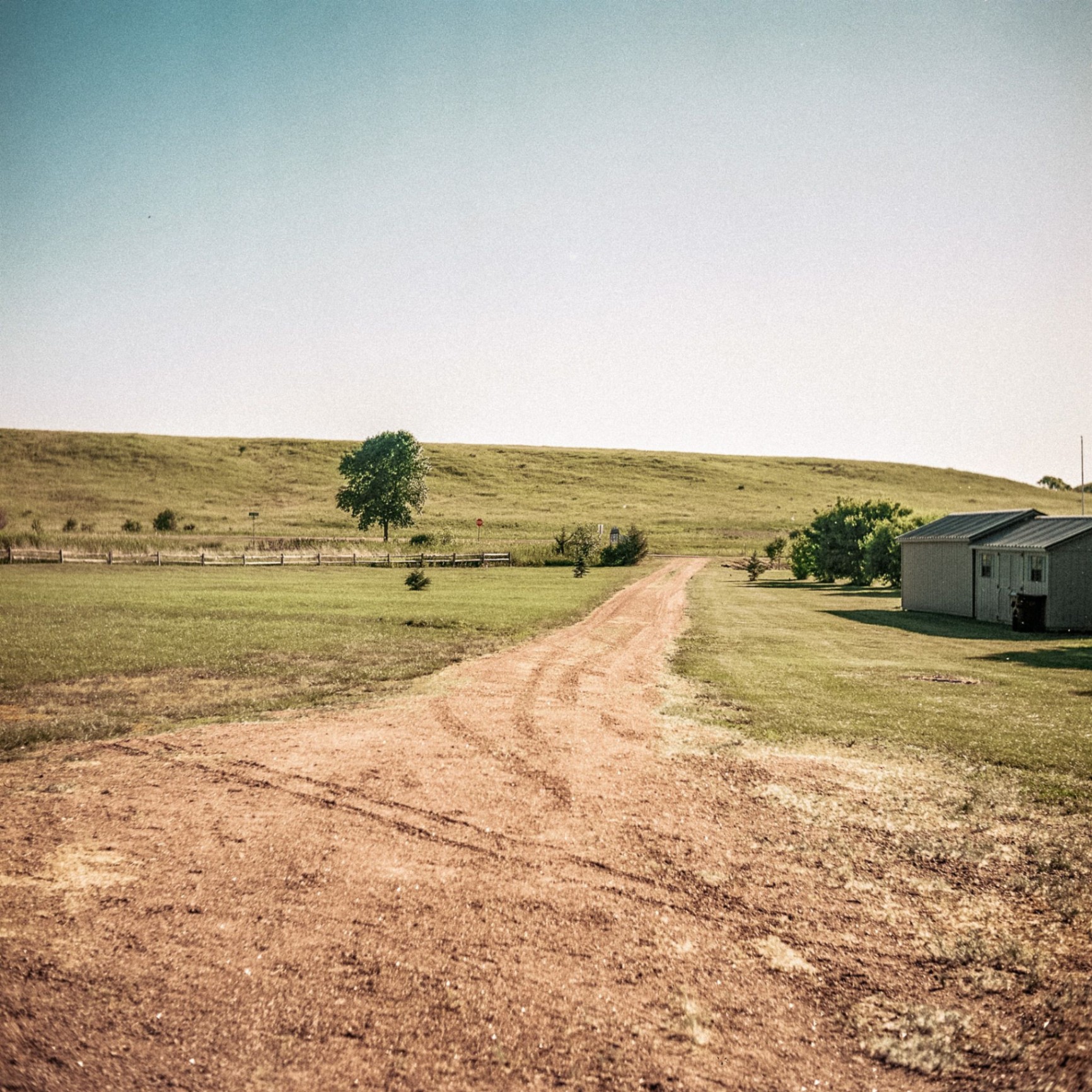 Ranch driveway with shed and rolling hills