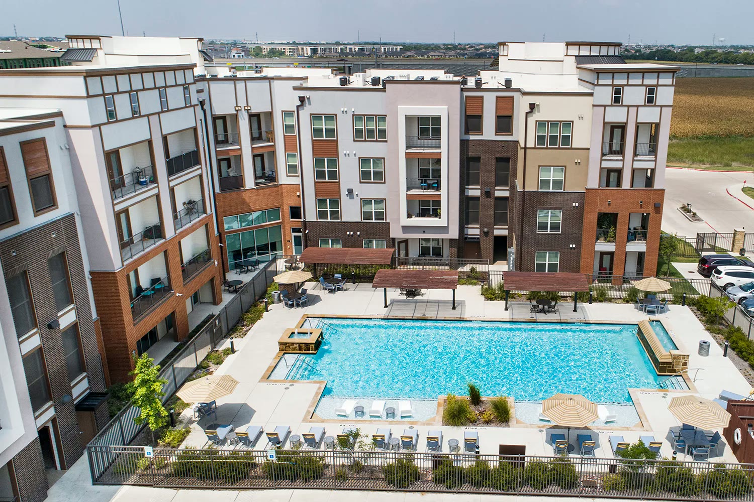 Aerial of luxury apartment complex with resort pool and pergolas