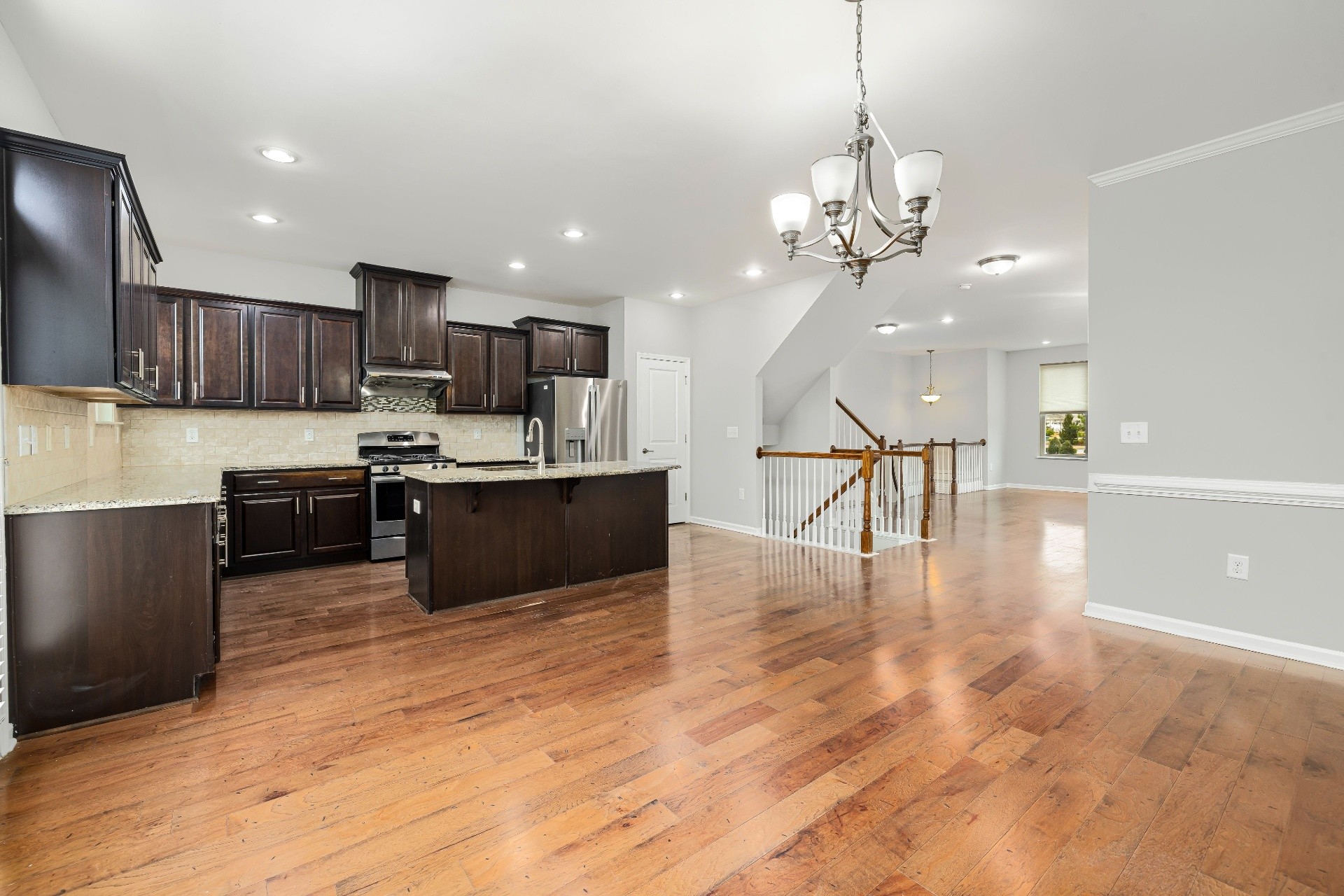 Interior 70348 — open-concept kitchen with dark cabinets and hardwood floors