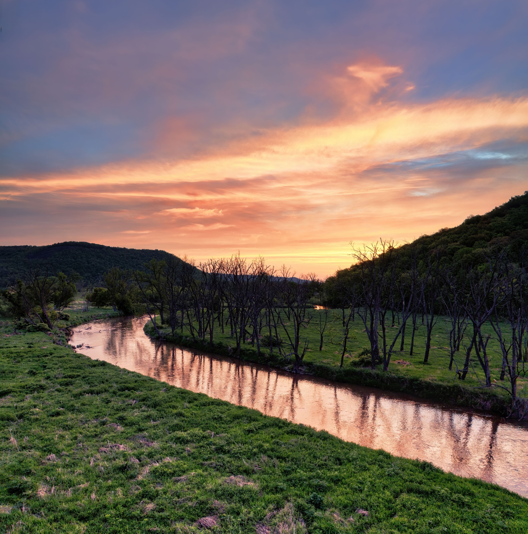 River winding through ranch land at sunset