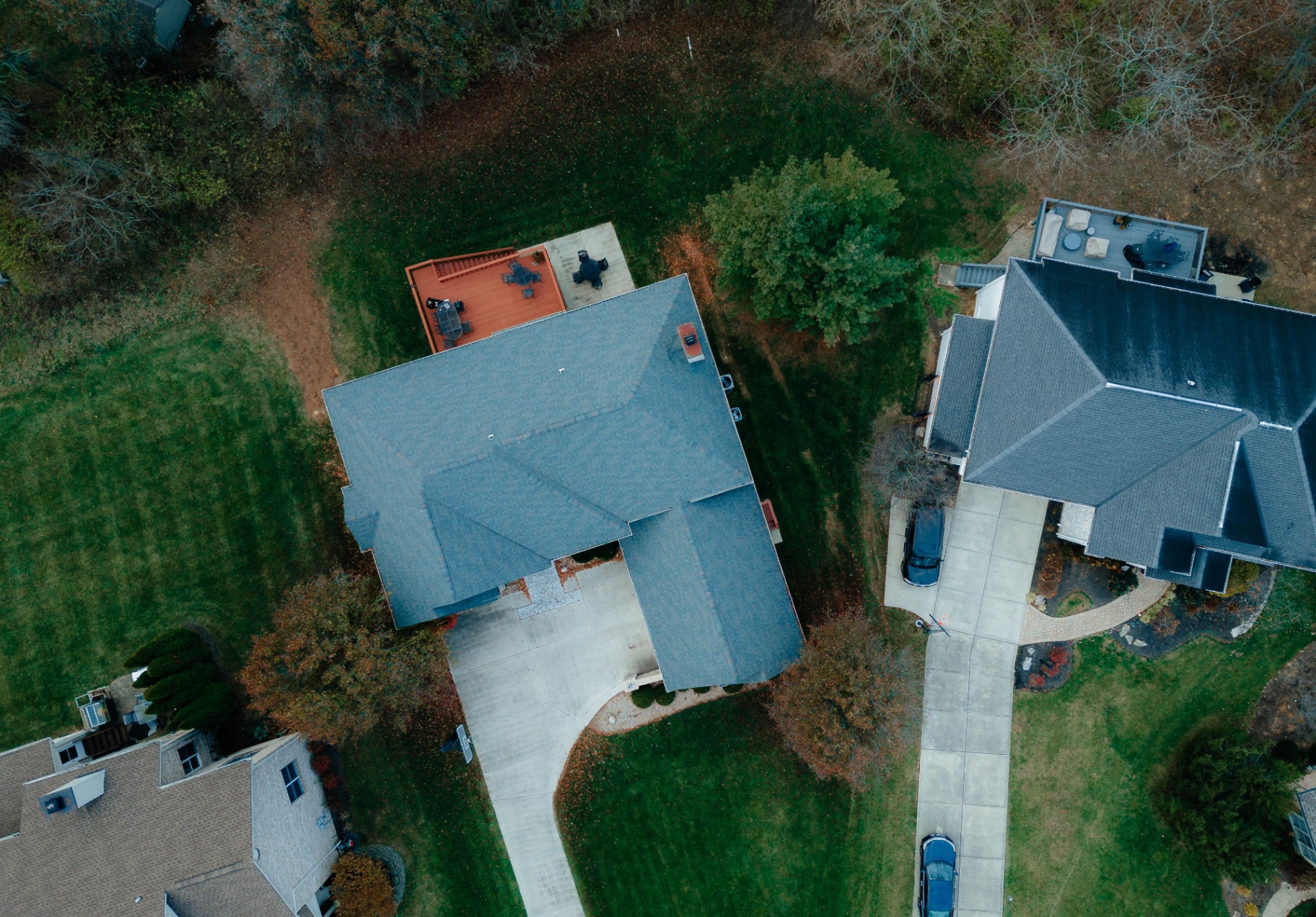 Top-down aerial of home with rear deck and yard